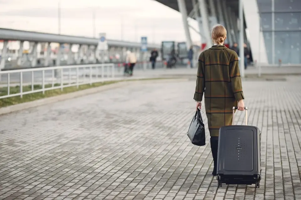 Traveller with a suitcase outside an airport terminal – Hammersmith and Fulham to Gatwick transfer
